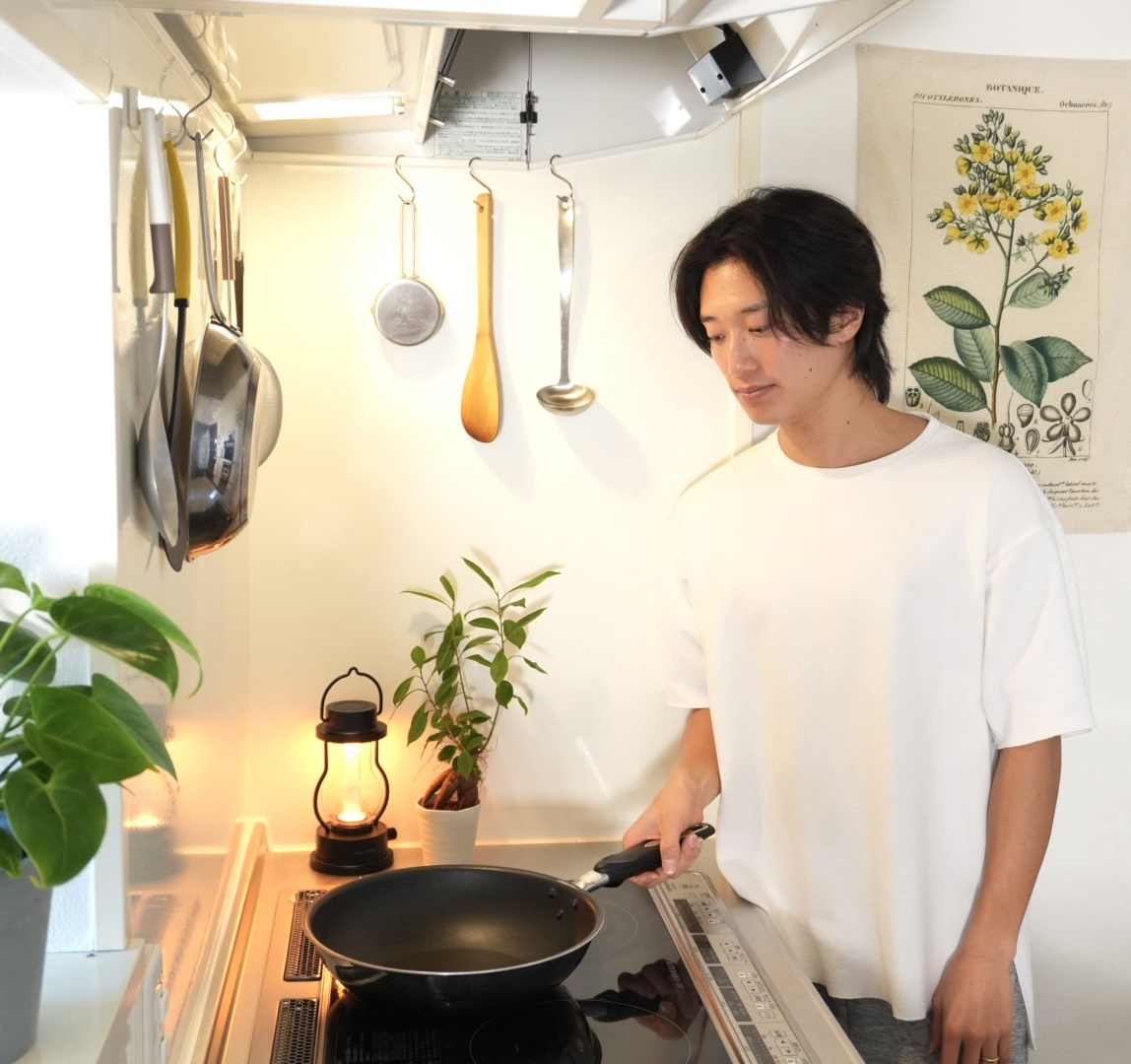 キッチンでフライパンを手にしているしょえ